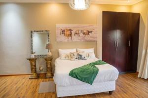 a bedroom with a large bed and a mirror at Gorge View. in Mbabane