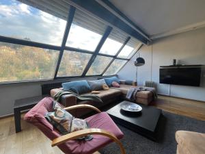 a living room with a couch and a tv at Amazing Penthouse old town in Sarajevo