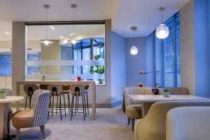 a dining room with tables and chairs and blue walls at AC Hotel Carlton Madrid by Marriott in Madrid