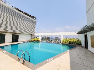 - une grande piscine sur le côté d'un bâtiment dans l'établissement Dimora Hotels And Resorts, à Trivandrum