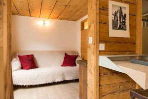 a room with a white couch with red pillows at Boutique Hotel The River House in Andermatt