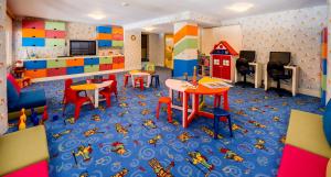 une salle de jeux avec des tables et des chaises et une maison de jouets dans l'établissement Vuni Palace Hotel & Casino & SPA, à Kyrenia