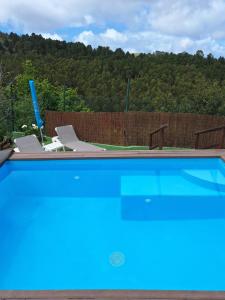 una gran piscina azul con una valla de madera en Finca Esther, en Las Palmas de Gran Canaria