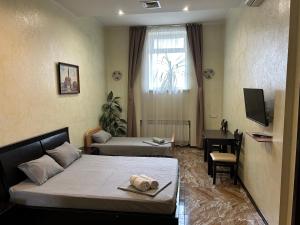 a bedroom with a bed and a desk and a television at Mini Hotel Smak in Dnipro