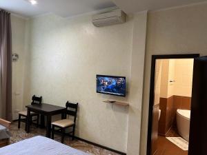 a room with a table and a bathroom with a television at Mini Hotel Smak in Dnipro