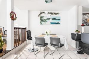 une salle à manger blanche avec une table et des chaises dans l'établissement Luxueux condo au cœur de Québec!, à Québec