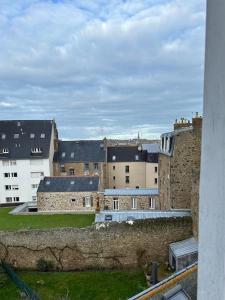 une vue sur un groupe de bâtiments depuis une fenêtre dans l'établissement Studio cozy Saint-Malo, à Saint-Malo