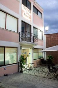 - un bâtiment avec un balcon et des bancs devant dans l'établissement Hotel Tlaxcala, à Tlaxcala de Xicohténcatl