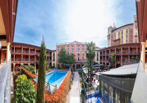 - une vue sur la cour d'un immeuble avec piscine dans l'établissement 4-Sterne Erlebnishotel El Andaluz, Europa-Park Freizeitpark & Erlebnis-Resort, à Rust