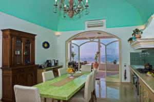 uma cozinha com uma mesa com cadeiras e uma sala de jantar em Villa Santa Chiara Positano Suites em Positano