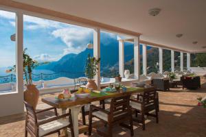 uma sala de jantar com uma mesa e vista para uma montanha em Villa Santa Chiara Positano Suites em Positano