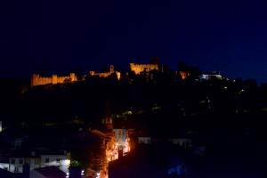 uma cidade iluminada à noite com um castelo numa colina em O Paço - exclusive accommodation em Tomar