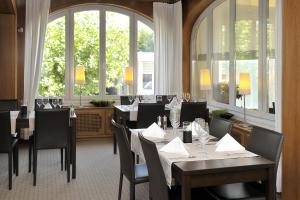 Aparthotel-aarau-WEST Swiss Quality في Oberentfelden: غرفة طعام مع طاولات وكراسي ونوافذ