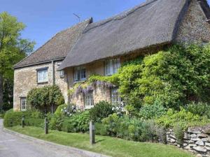 une grande maison en pierre avec un toit en gazon dans l'établissement Cosy retreat in the heart of the Cotswolds., à Chipping Norton