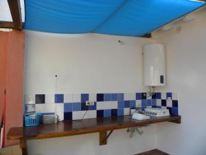 een keuken met een wastafel en een blauw plafond bij Casa do Mar in Figueira da Foz