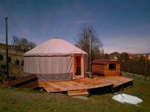 yurta con terraza de madera en un campo en Owcza Jurta, en Dursztyn