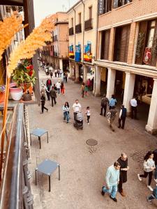 a group of people walking down a street at calle mayor in Alcalá de Henares