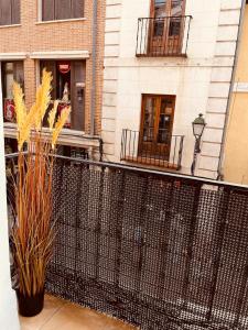 a balcony with a black fence in front of a building at calle mayor in Alcalá de Henares