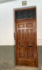 a wooden door with a clock on top of it at calle mayor in Alcalá de Henares