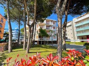 una fila de árboles frente a un edificio en Frontemare 6 posti letto + posto auto gratuito, en Bibione