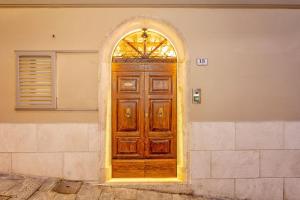 una porta in legno con finestra ad arco su un edificio di Palazzo Falcinelli Luxury Room in Montepulciano Center with Elevator a Montepulciano