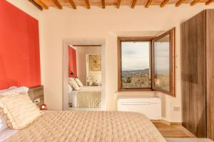 una camera con un letto e un grande specchio di Palazzo Falcinelli Luxury Room in Montepulciano Center with Elevator a Montepulciano