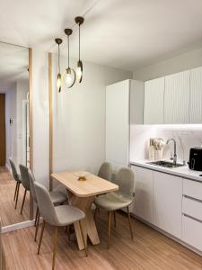 Il comprend une cuisine et une salle à manger avec une table et des chaises en bois. dans l'établissement Nomad Stay Apartments, à Durrës