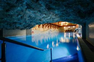 una piscina in una grotta con acqua blu di Hotel Belvedere Resort&SPA a Zakopane