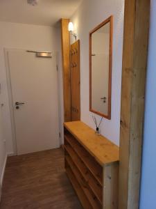 y baño con tocador de madera y espejo. en Ferienwohnung im Dachgeschoss mit Aufzug, en Rostock