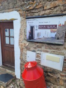 una boca de incendios roja frente a una pared de piedra en Estúdio Tia Anica, en Reguengos de Monsaraz