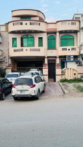 un edificio con auto parcheggiate di fronte di Madcrew Lodge a Islamabad