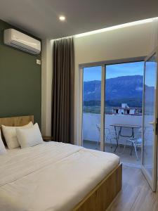 1 dormitorio con 1 cama y balcón con mesa en Patio Rooms Gjirokaster, en Gjirokastra