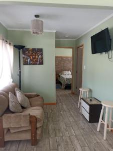 a living room with a couch and a flat screen tv at Cabañas Vicuña Cielo de Peralillo - Valle de Elqui in Vicuña