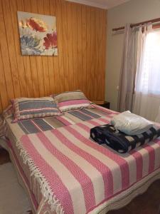 a bed with a striped comforter in a bedroom at Cabañas Vicuña Cielo de Peralillo - Valle de Elqui in Vicuña