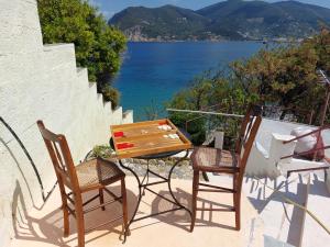 un tavolo e due sedie su un balcone con vista sull'acqua di Maeiz Skopelos a Skopelos Town