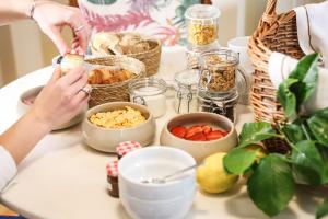 une femme fait de la nourriture sur une table avec d'autres aliments dans l'établissement Entre Ruas Apartments, à Coimbra