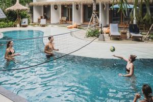 - un groupe de personnes jouant au volley-ball dans une piscine dans l'établissement Roomates Surf Camp Canggu by Ini Vie Hospitality, à Canggu