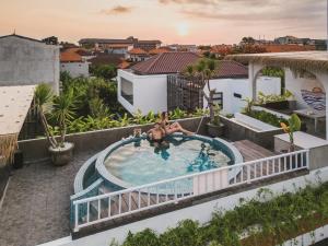 une image d'une piscine sur le toit d'une maison dans l'établissement Roomates Surf Camp Canggu by Ini Vie Hospitality, à Canggu