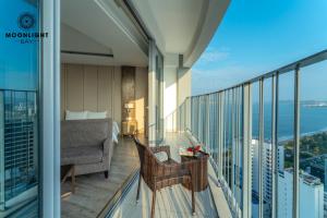 - un balcon avec un canapé et une chaise dans un bâtiment dans l'établissement Moonlight Bay Panorama Condotel Ocean View, à Nha Trang