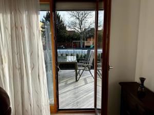 une porte coulissante en verre menant à une terrasse avec une table. dans l'établissement AJO Vienna Ambassador Family House with Free Parking, à Vienne