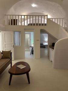 a living room with a couch and a spiral staircase at Remezzo Villas in Imerovigli