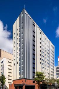 um edifício branco alto com muitas janelas em Via Inn Prime Sapporo Odori em Sapporo