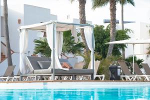 a pool with chairs and a gazebo next to a swimming pool at Labranda Bahía de Lobos in Corralejo