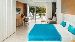 a hotel room with a blue bed and a balcony at Labranda Bahía de Lobos in Corralejo