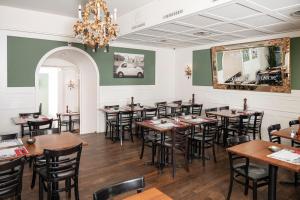 a dining room with tables and chairs and a chandelier at Boutique Hotel Weisses Kreuz - Adult only Hotel in Luzern