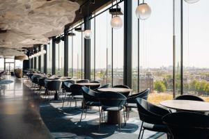 een rij tafels en stoelen in een kamer met ramen bij DoubleTree by Hilton Amsterdam Centraal Station in Amsterdam