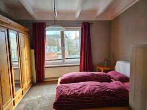 1 dormitorio con 1 cama y una ventana con cortinas rojas en Ferienwohnung im Dachgeschoss mit Aufzug, en Rostock