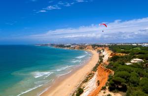 een persoon die vliegert over een strand bij Apartamentos Atlantico by OA in Albufeira