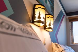 een slaapkamer met twee lampen aan de muur bij Astoria Hotel in Jasper