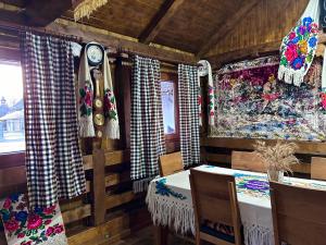 um quarto com uma mesa, cadeiras e cortinas em Casa Chindris em Ocna Şugatag